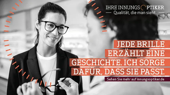 Eine lächelnde Frau mit dunklen Haaren und Brille unterhält sich mit jemandem, dessen Rücken teilweise sichtbar ist. Sie hält eine Brille hoch und scheint einem Kunden bei der Auswahl zu helfen. Die Szene suggeriert eine hilfsbereite und freundliche Interaktion in einem Optikergeschäft. Der Text lautet: „JEDE BRILLE ERZÄHLT EINE GESCHICHTE. ICH SORGE DAFÜR, DASS SIE PASST.“